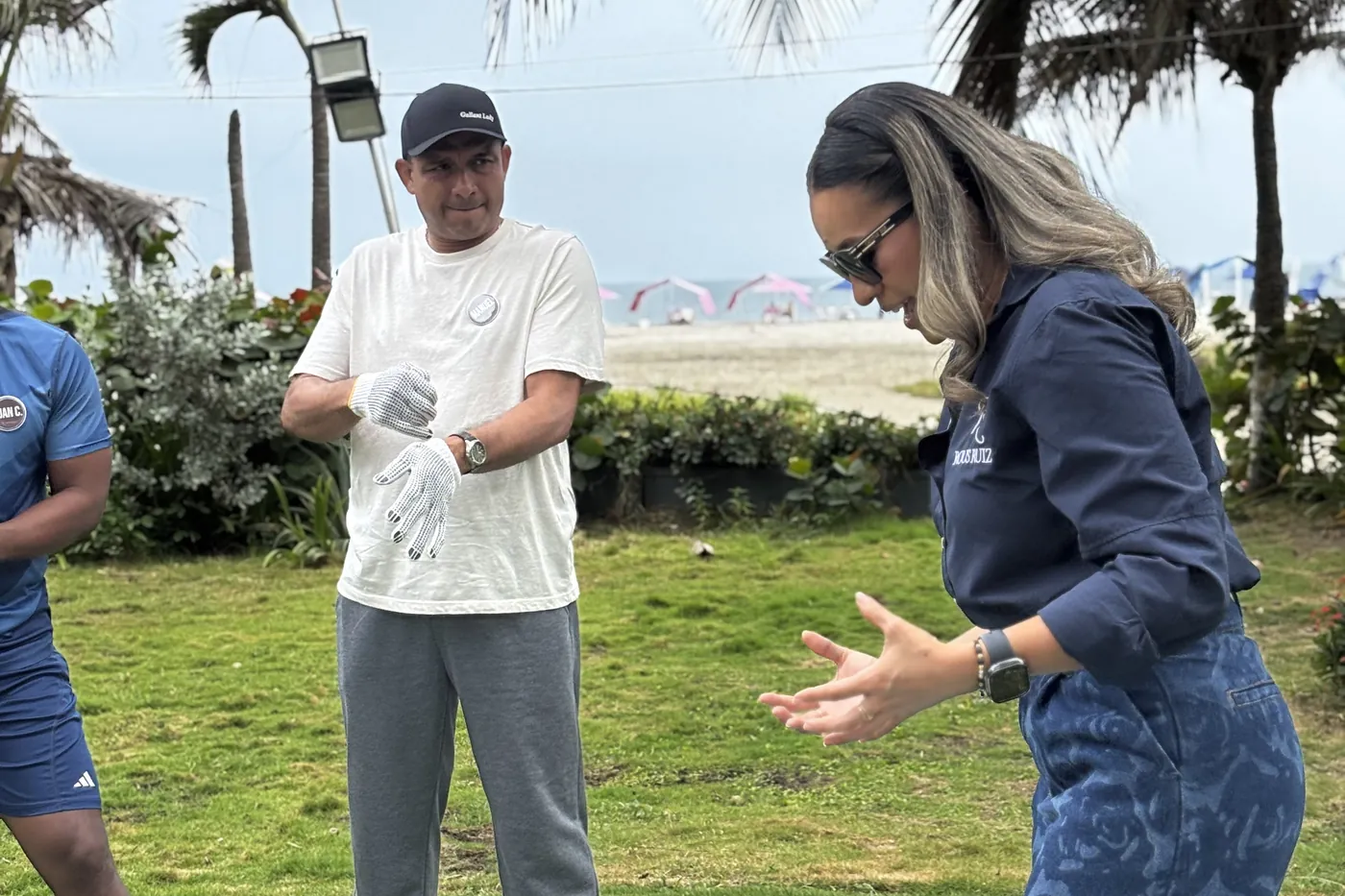 Rous Ruiz guiando un reto de team building al aire libre con un equipo, en la grama frente a la playa