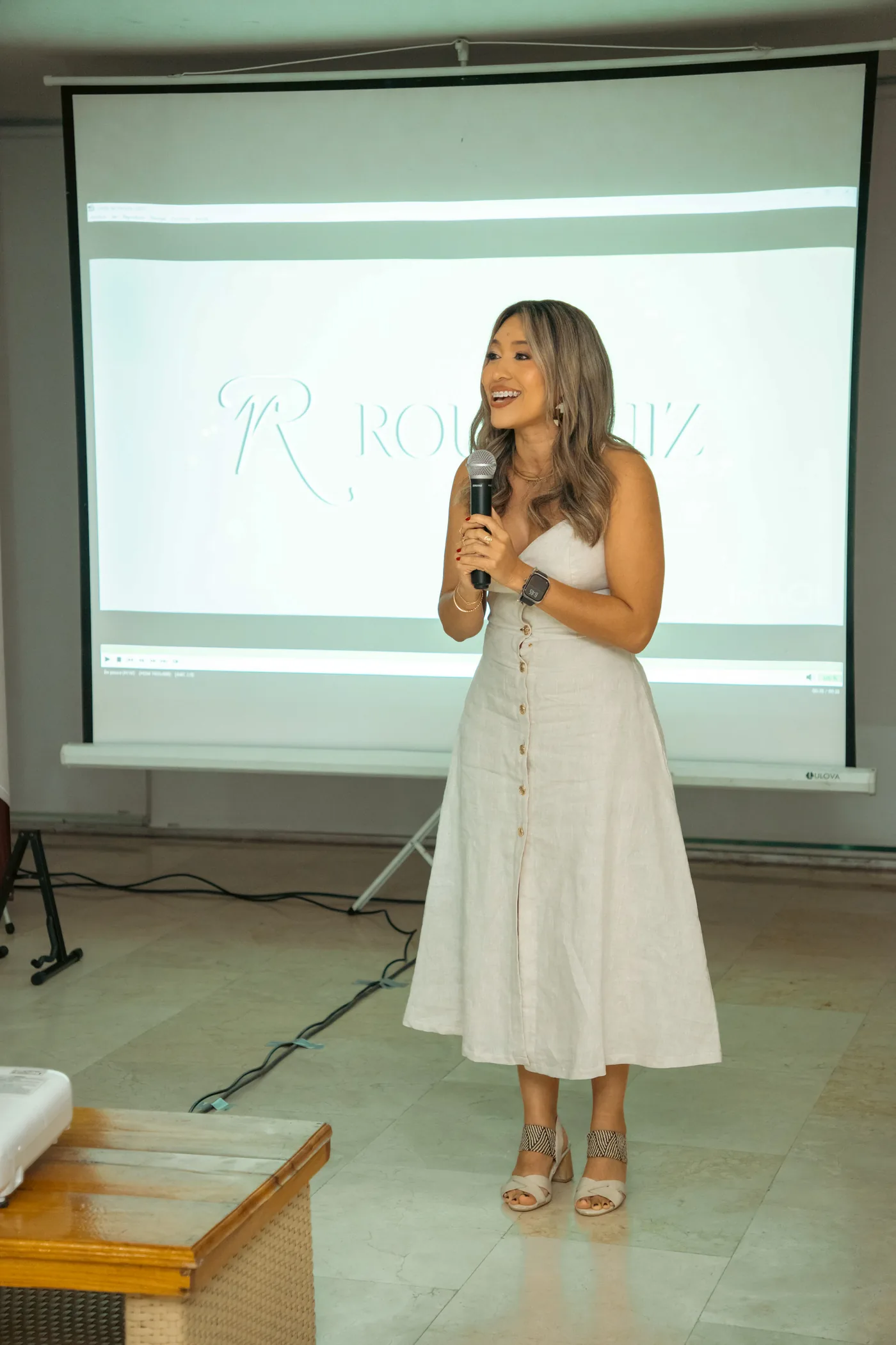 Rous Ruiz facilitando con micrófono, lista para conversar con tu equipo